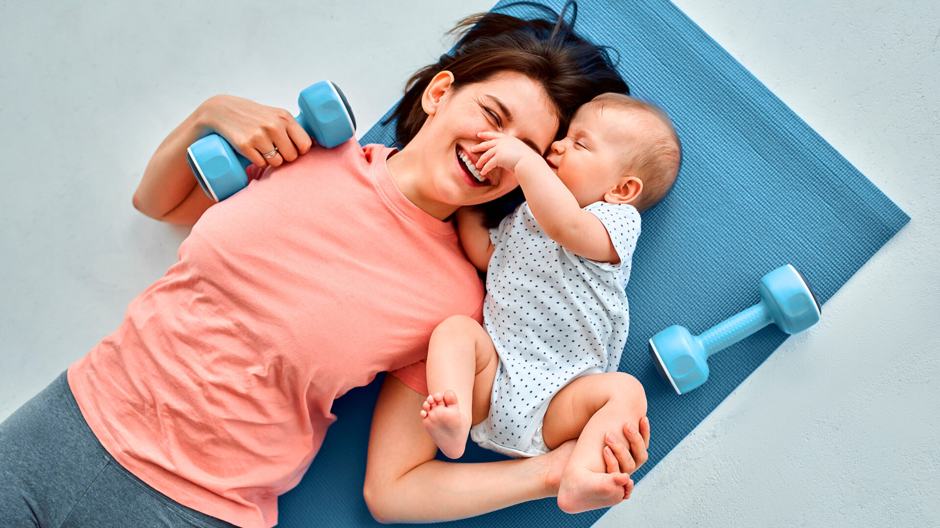 vrouw met baby liggend op sportmat