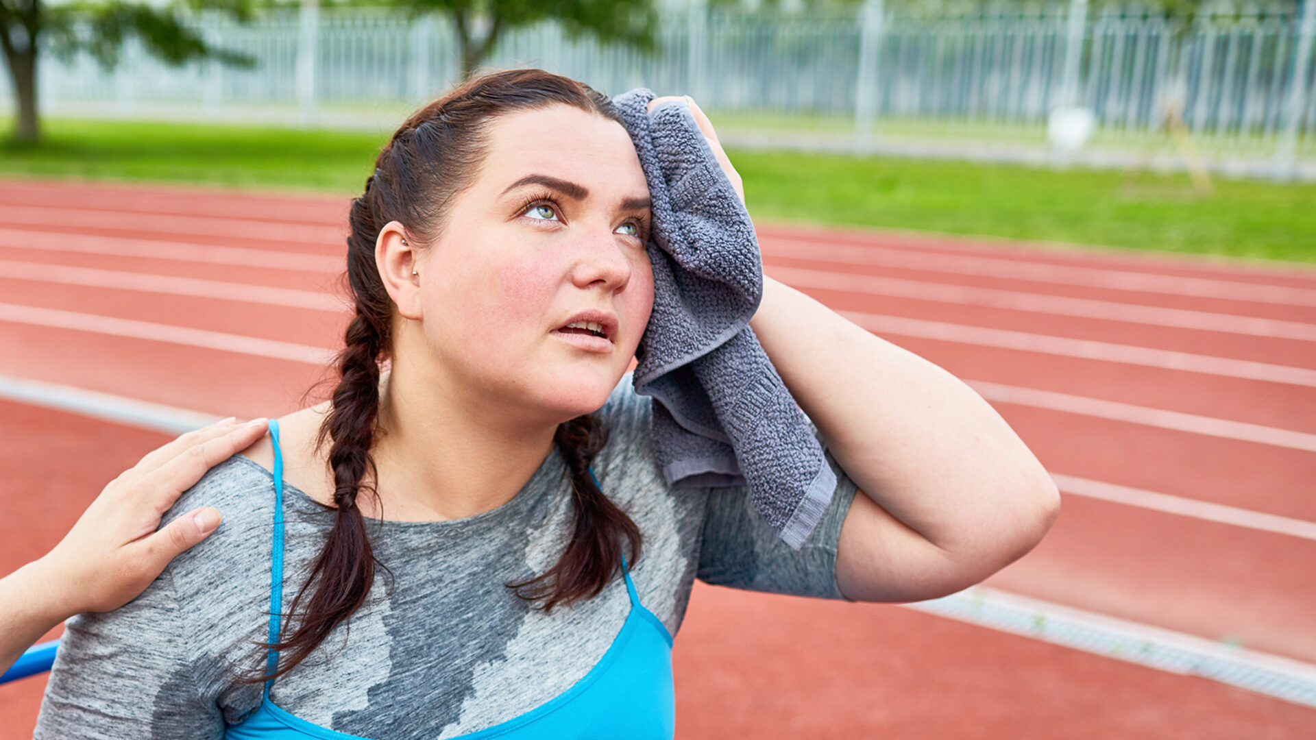 Vrouw met een handdoek en een bezweet shirt