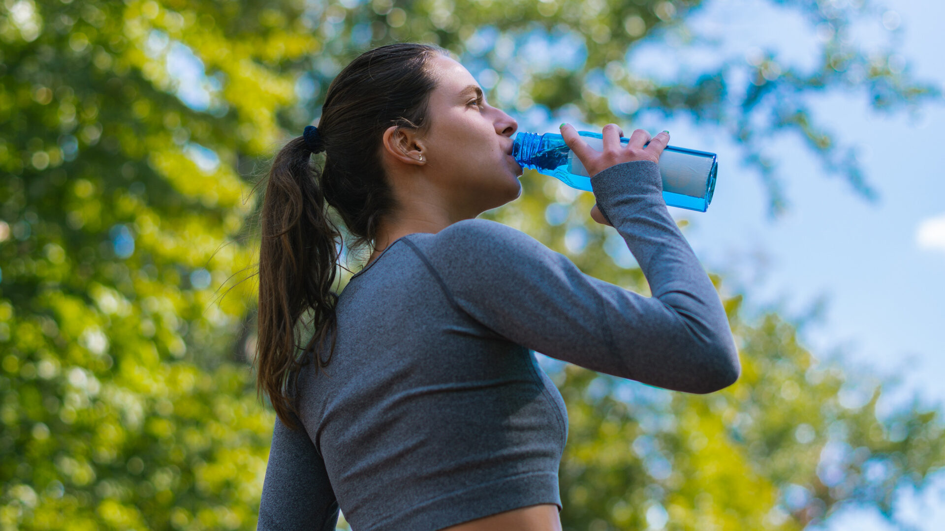 Vrouw neemt een slok uit een drinkfles