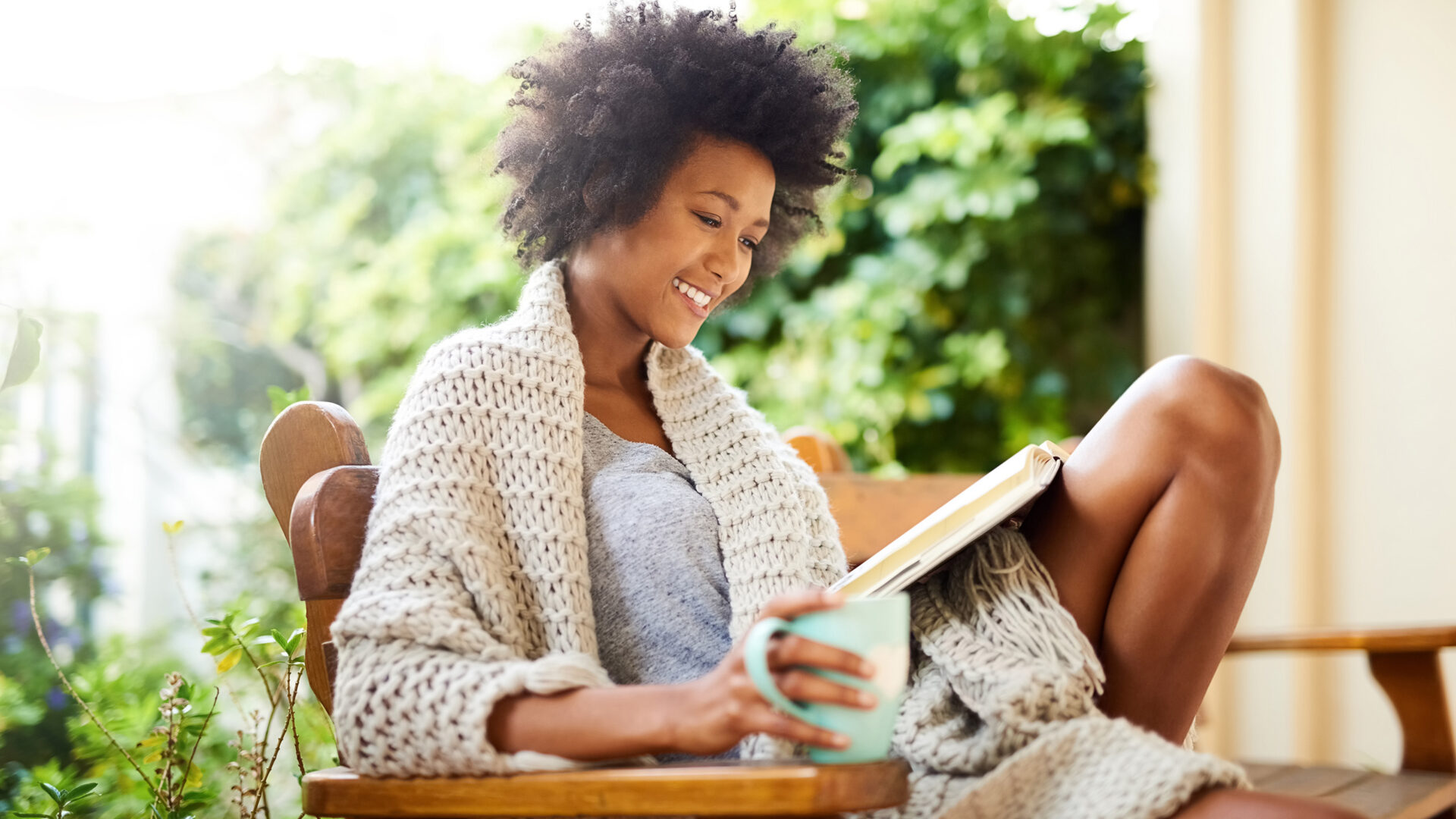 Vrouw op een stoel in de tuin met een boek