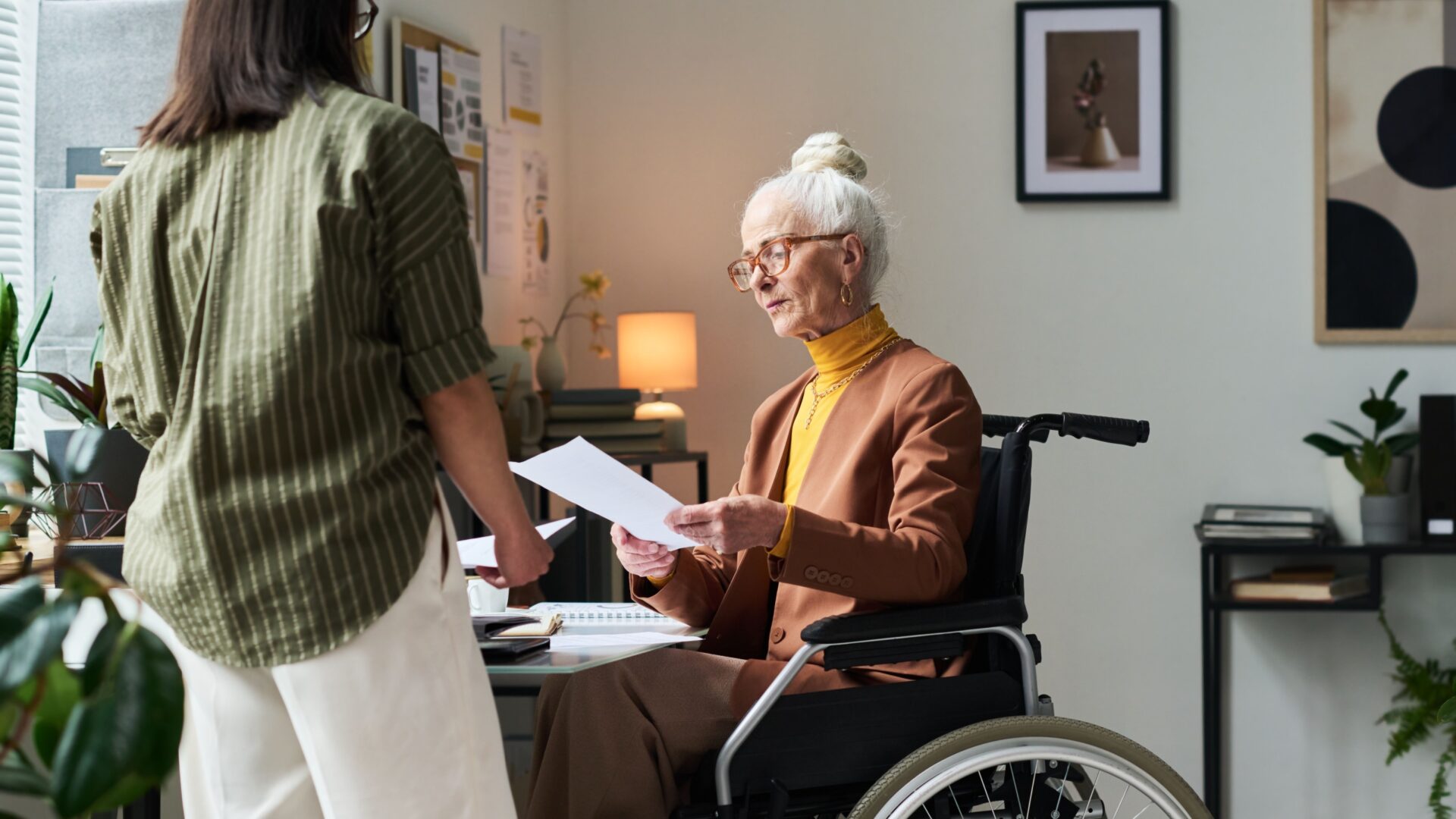 Vrouw in rolstoel houdt papier vast