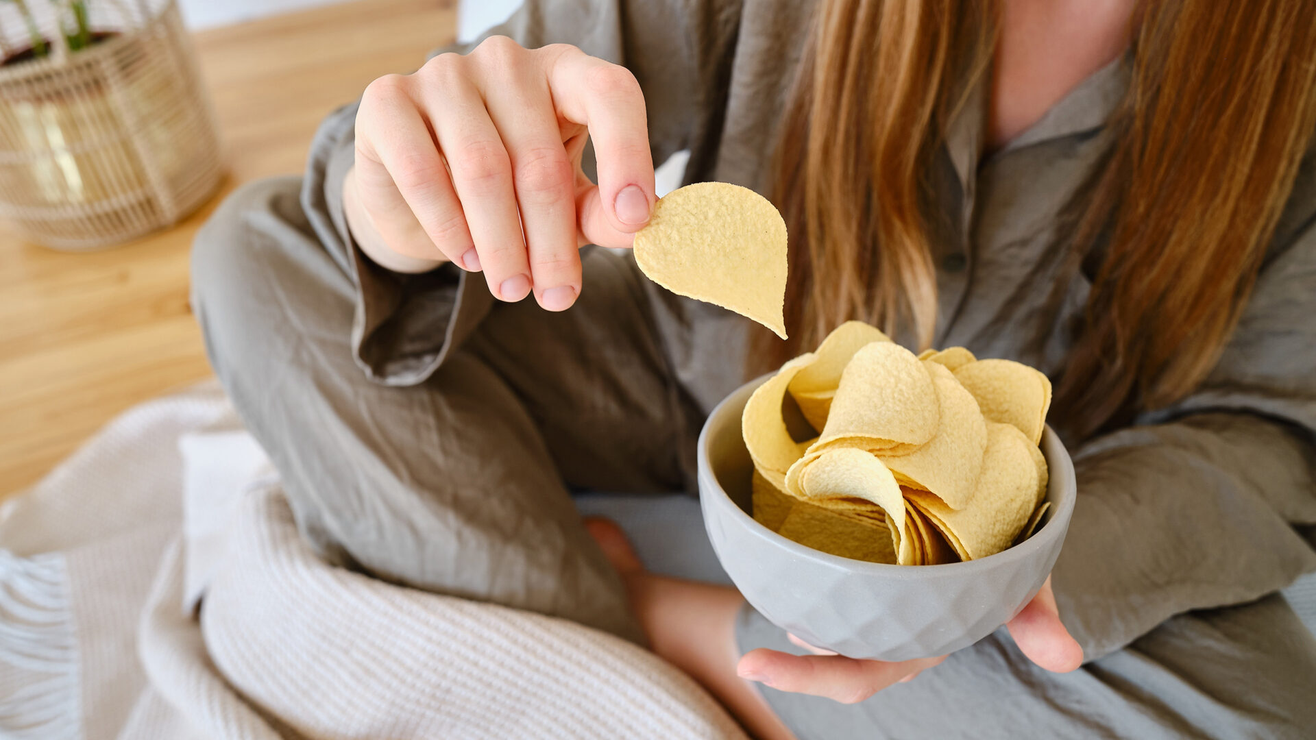 Vrouw eet chips uit een bakje