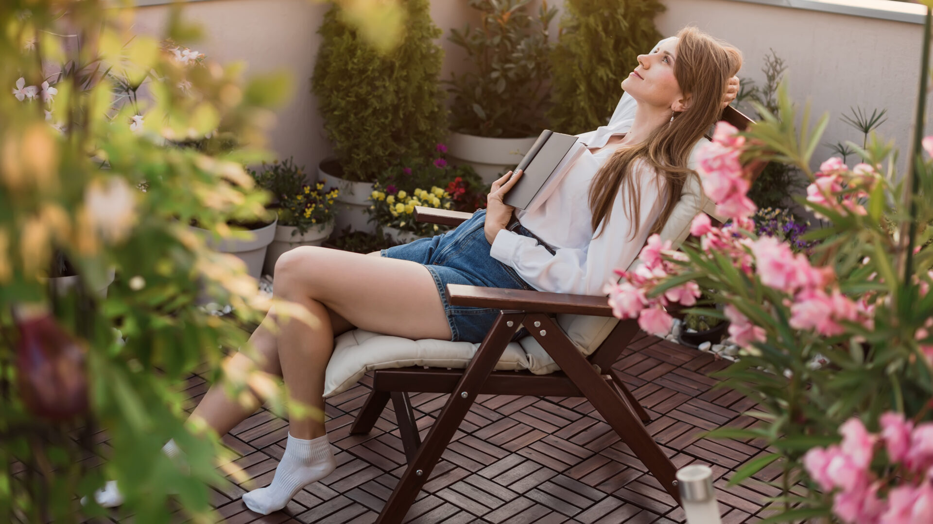 Vrouw op een tuinstoel tussen kleurrijke planten