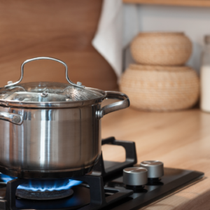 een pan die op het gasfornuis staat in de keuken met het vuur aan zodat ze kunnen koken
