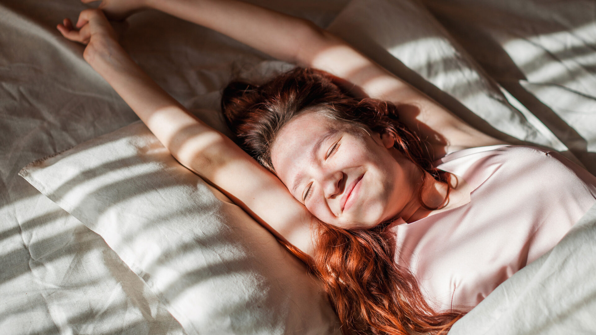 Vrouw strekt zicht uit in bed