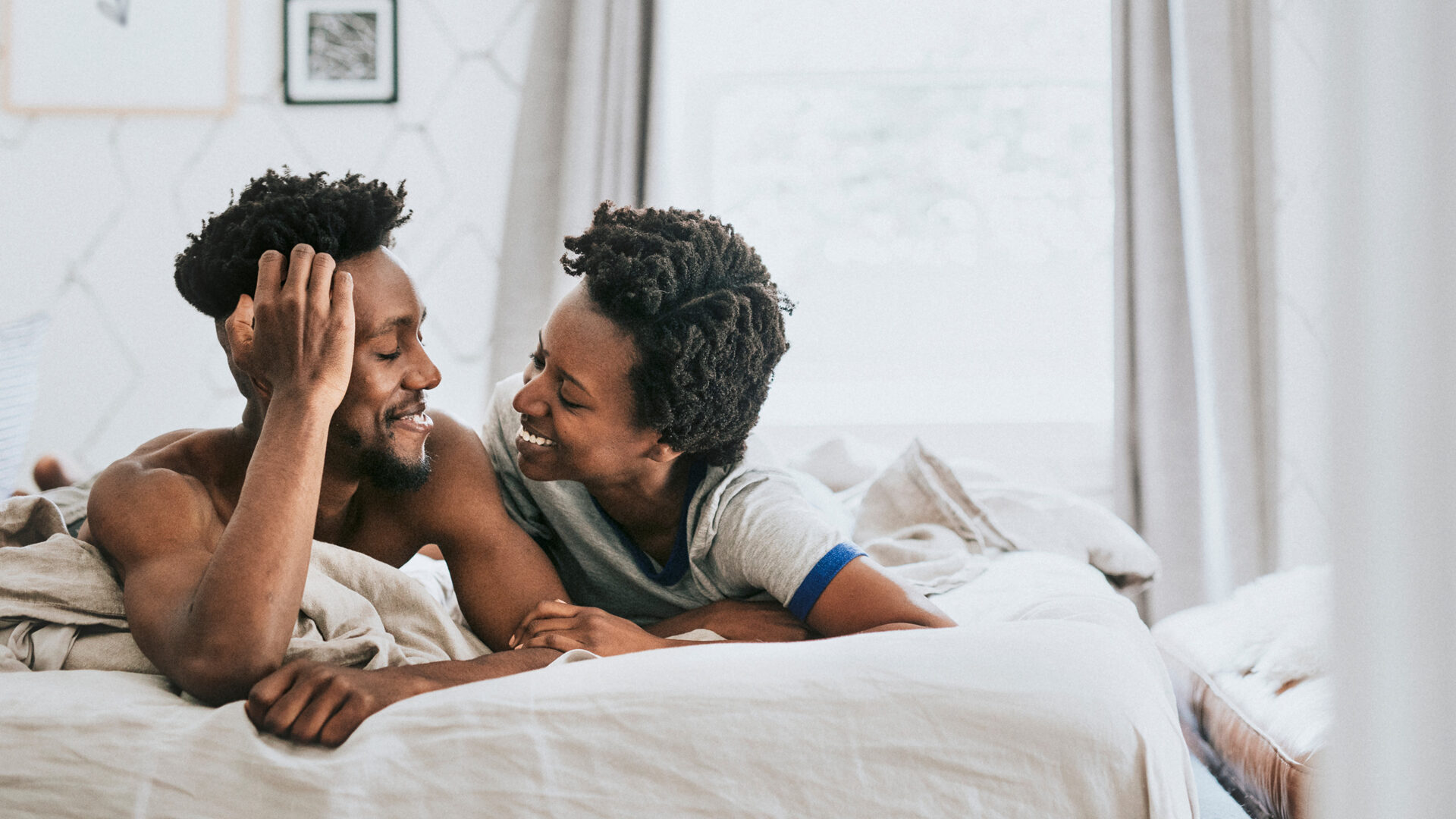 Man en een vrouw lachend in bed