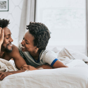 Man en een vrouw lachend in bed