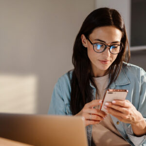 Vrouw met laptop en telefoon in handen