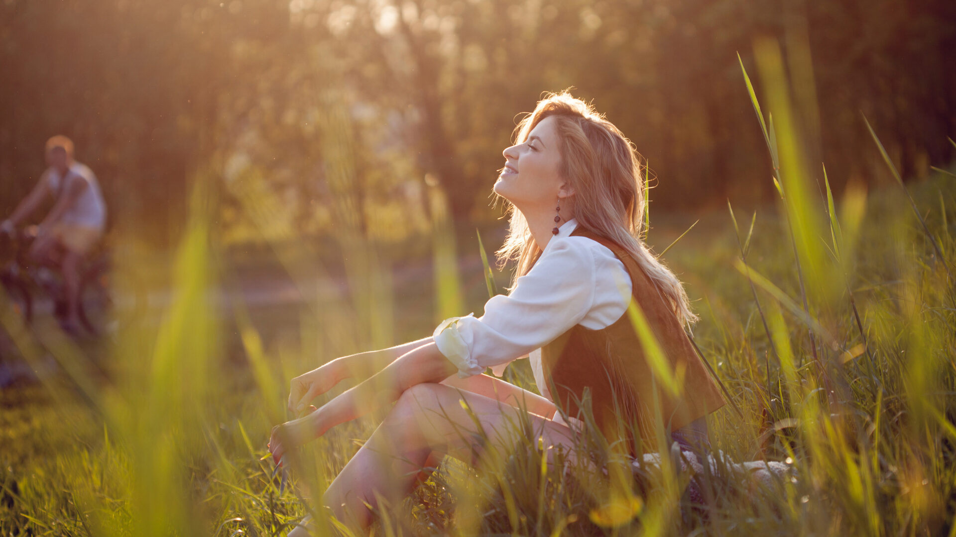 Vrouw zit op het gras in de natuur