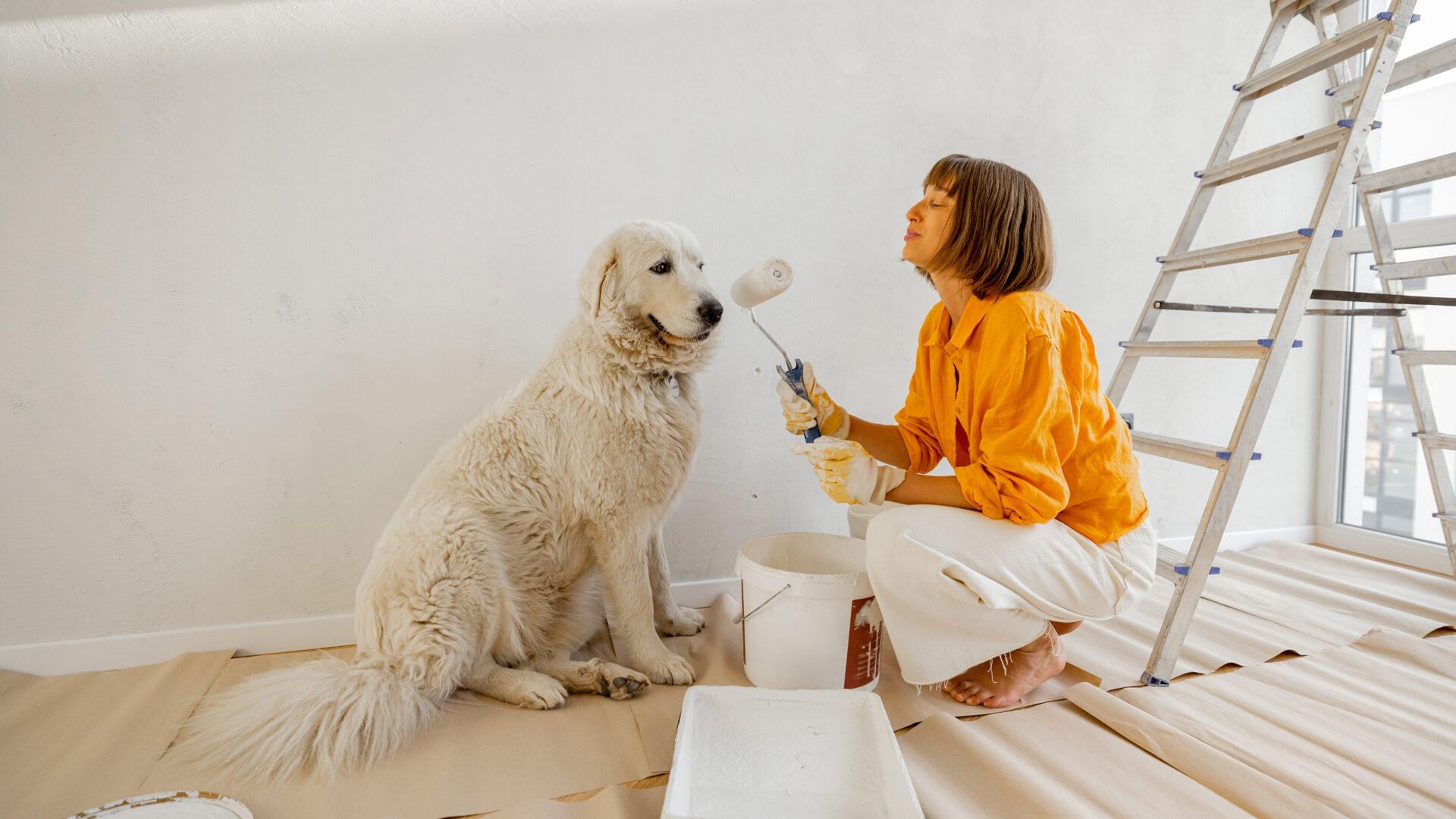 Vrouw met verfroller en golden retriever