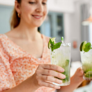 vrouw met twee glazen frisdrank in handen