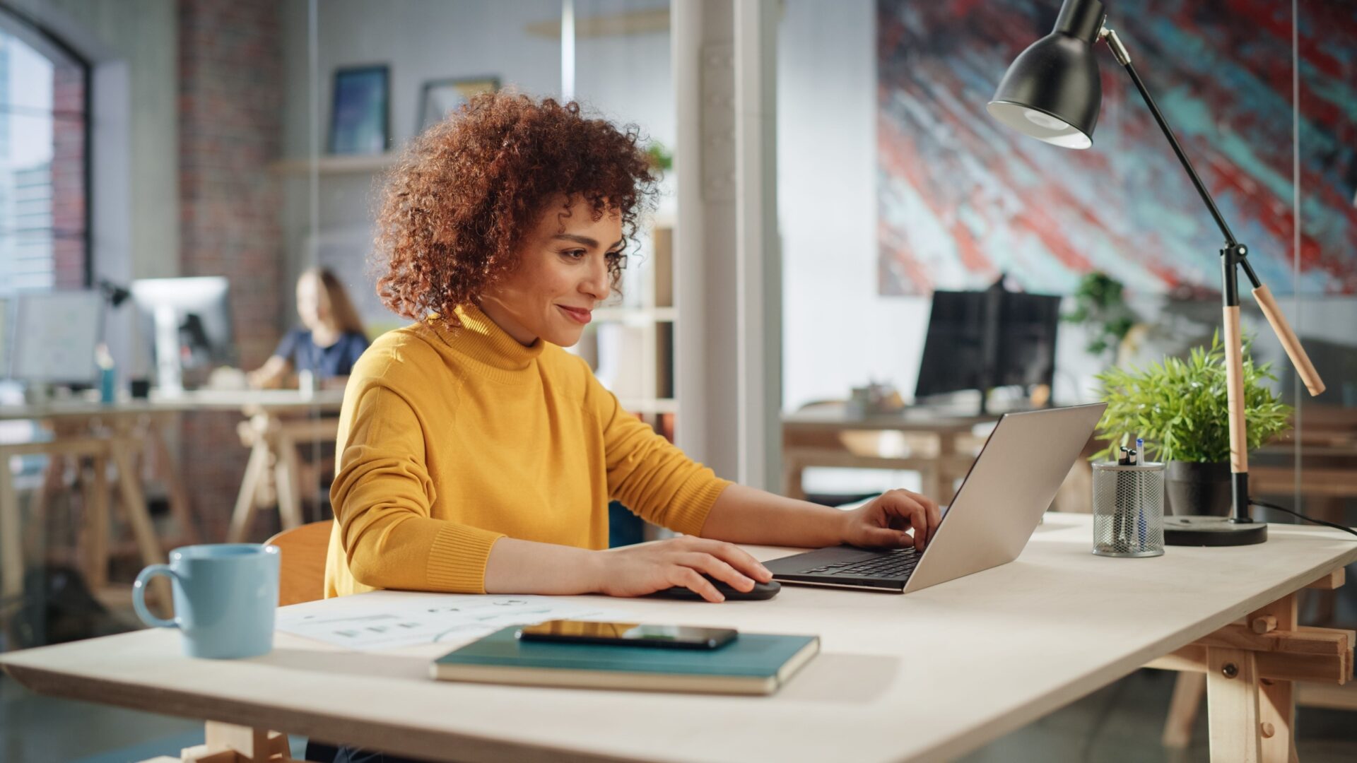 Vrouw achter een laptop aan een bureau