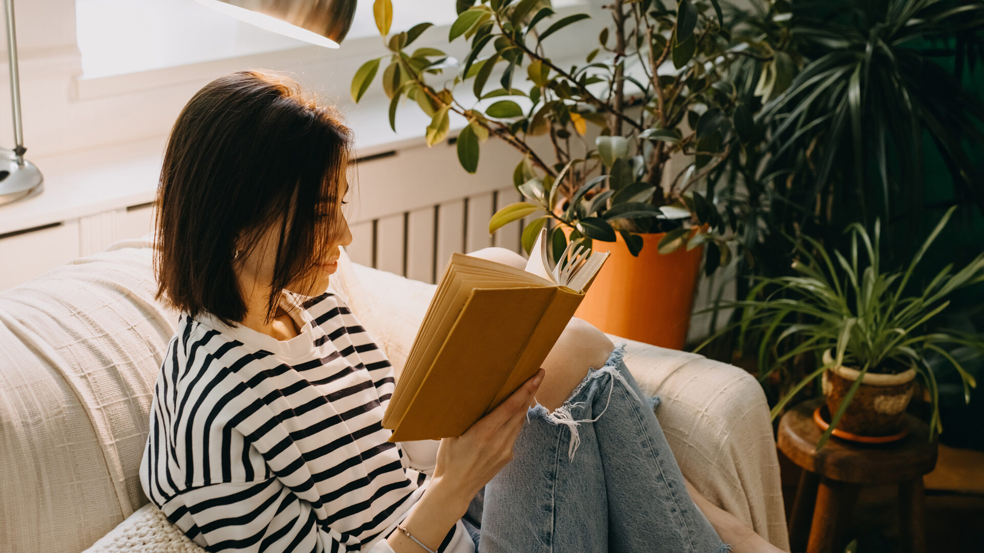 Vrouw met boek op de bank