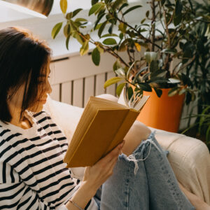 Vrouw met boek op de bank