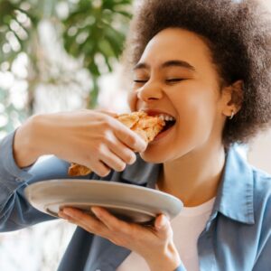 Vrouw eet een bladerdeeggebakje