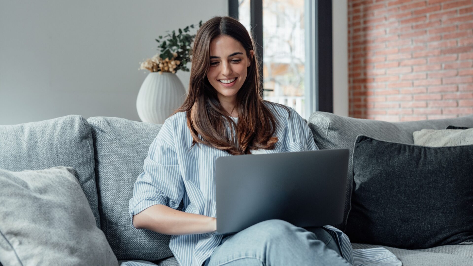 Vrouw met laptop op de bank