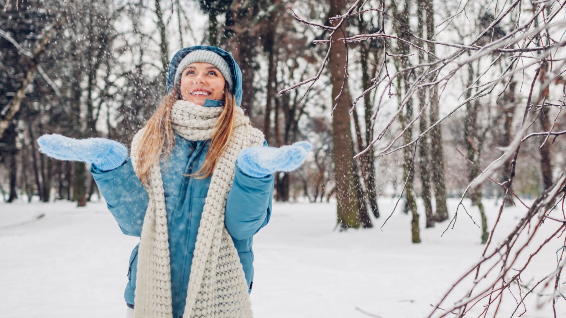 Vrouw met handschoenen aan in de sneeuw