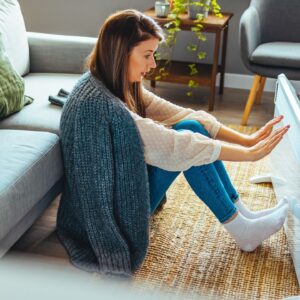 Vrouw houdt voeten tegen verwarming aan