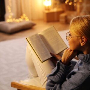 Vrouw leest boek voor de kachel